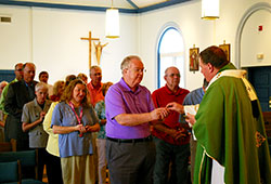 Jack Meany, a member of St. Margaret Mary Parish in Terre Haute, receives Communion from Archbishop Joseph W. Tobin during an Aug. 13 Mass at Sacred Heart of Jesus Church in Terre Haute. Meany and other Catholics from the Terre Haute Deanery involved in the deanery&rsquo;s planning process and the implementation of that plan came together with the archbishop for the Mass and dinner that followed. (Submitted photo by Patty Mauer)