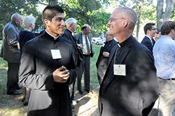 Father Martin Rodriguez, associate pastor of St. Monica Parish in Indianapolis, chats with Bishop Paul D. Etienne of Cheyenne, Wyo., on Sept. 8 on the grounds of Bishop Simon Brut&eacute; College Seminary in Indianapolis during a celebration of the 10th anniversary of the seminary&rsquo;s founding. Father Rodriguez is a graduate of the seminary. Bishop Etienne served as a vice rector of the seminary while a priest of the Archdiocese of Indianapolis. (Photo by Sean Gallagher)