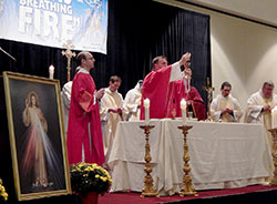 Archbishop Joseph W. Tobin raises the Eucharist on Sept. 20 during a Mass at the eighth Indiana Catholic Men&rsquo;s Conference at the Indianapolis Marriott Downtown. More than 400 men attended. (Photo by Mike Krokos)