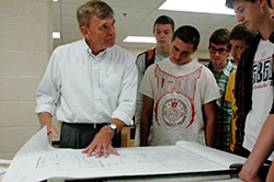 Roncalli High School teacher James Ratliff shows a blueprint to students during one of his architecture classes. Ratliff&rsquo;s students have won a national architectural design contest 10 times in the past 18 years. (Photo by John Shaughnessy)