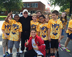 Father Daniel Atkins, pastor of Holy Family Parish in New Albany, poses on Sept. 18 with students at the parish&rsquo;s school during a walkathon it sponsored. (Submitted photo)