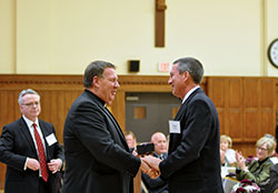 During a meeting of the Catholic Community Foundation (CCF) on Oct. 29 at the Archbishop Edward T. O&rsquo;Meara Catholic Center in Indianapolis, Archbishop Joseph W. Tobin presents George Kempf with a gift of appreciation for his five years of service on the foundation&rsquo;s board of trustees and as a volunteer advisor on the CCF professional advisory group. (Photo by Natalie Hoefer)