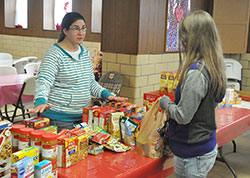 Jennifer Bailey, a member of Annunciation Parish in Brazil, helps a client of the parish&rsquo;s food pantry on Feb. 3. The pantry, which is operated by a conference of the Society of St. Vincent de Paul based in the parish, serves more than 200 households per month. (Photo by Sean Gallagher)
