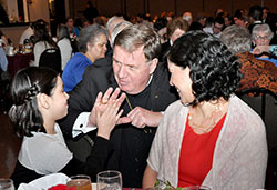 Archbishop Joseph W. Tobin gives a high-five to 7-year-old Sara Cabrera as the girl&rsquo;s mother, Maria Hernandez, smiles during the annual Sanctity of Life Dinner on March 11 in Indianapolis. Sara, a second-grader at West Newton Elementary School and a member of St. Ann Parish, both in Indianapolis, wrote a letter to President Barack Obama encouraging him to change his pro-abortion stance and become a pro-life president. (Photo by Natalie Hoefer)