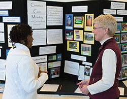 Sharon Horvath, right, a science teacher at St. Thomas Aquinas School in Indianapolis and a member of that parish&rsquo;s Creation Care Ministry, shares ideas on March 28 with Domoni Rouse, who is interested in starting a green ministry at St. Rita Parish in Indianapolis. They were standing steps away from the chapel housed inside Marian University&rsquo;s Evans Center for Health Sciences, which recently received LEED (Leadership in Energy and Environmental Design) Gold certification in recognition of its environmentally friendly design.&nbsp;All of the wood furniture in the chapel was constructed from the black walnut trees that once stood on the site. (Photo &copy; Denis Ryan Kelly Jr.)