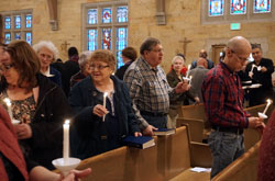 Judy and Bob LaEace, members of St. Michael the Archangel Parish in Indianapolis, hold candles during a March 11 ecumenical prayer service at their parish&rsquo;s church. St. Michael and three other nearby Christian congregations on Indianapolis&rsquo; west side have deepened their ecumenical relationship through prayer and discussion of race relations. (Submitted photo)