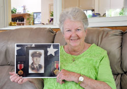 After nearly 60 years of wondering about the life of her biological father, Muriel &ldquo;Mimi&rdquo; Riffle finally learned about him&mdash;a journey of faith that also led her to a new family connection. Here, the member of St. Agnes Parish in Nashville poses with a photo of her father, Francis Flagg, who served in the U.S. Army during World War II. (Photo by John Shaughnessy)