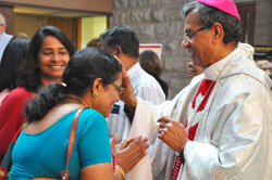 Bishop A. Jude Paulraj of the Diocese of Palayamkottai in India gives a blessing to Phelomina Fernando while her daughter, Leena Fernando, smiles in the narthex of St. Luke the Evangelist Church in Indianapolis on June 9. The bishop celebrated Mass there in thanksgiving for the parishioners&rsquo; donations to help build the cathedral in his diocese. Leena, a member at Our Lady of Mount Carmel Parish in Carmel, Ind., in the Lafayette Diocese, and her family lived at one time in the Palayamkottai Diocese. Her parents happened to be visiting her during the bishop&rsquo;s stop at St. Luke. (Photo by Natalie Hoefer)