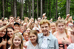 A sea of smiling children and youths at Camp Rancho Framasa in Brown County on June 17 give their thumbs-up signs of appreciation to Pat Cronin, the first counselor at the archdiocese&rsquo;s Catholic Youth Organization summer camp when it opened in 1946. (Photo by John Shaughnessy)