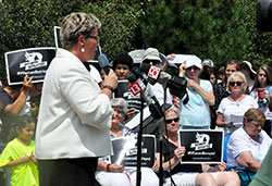 People hold signs for the #WomenBetrayed rally in Indianapolis on July 28 as Susan Swayze gives a speech. Swayze is vice president of Indiana Right to Life and national women&rsquo;s pro-life caucus coordinator of Susan B. Anthony List. The rally was one of 60 held nationwide, including one in Bloomington, to call for an investigation and national defunding of the abortion provider in light of recent videos revealing the organization&rsquo;s selling of body parts of aborted children. Nearly 200 people attended the Indianapolis rally. (Photo by Natalie Hoefer)