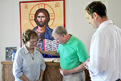 Paul Heerdink offers a prayer to God for Denise Sawyer as Scott Benningfield shares in the moment at St. John the Apostle Parish in Bloomington. The parish&rsquo;s prayer ministry uses a prayer station, a prayer book and a group of &ldquo;prayer warriors&rdquo; to help people through the challenges of life. (Photo by John Shaughnessy) 