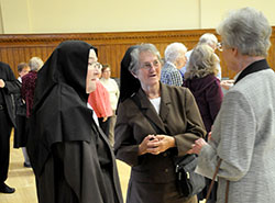 Three sisters from different orders in various locations across central and southern Indiana share stories in the Archbishop Edward T. O&rsquo;Meara Catholic Center in Indianapolis during a reception for all consecrated religious in the archdiocese on Sept. 13. They are Carmelite Sister Martha Hall of the Carmelite Monastery in Terre Haute, left; Franciscan Sister Martha Ann Rich of the Franciscan Sisters of Perpetual Adoration, who serves at St. Francis Hospital in Indianapolis; and Providence Sister Marilyn Herber of the Sisters of Providence at Saint Mary-of-the-Woods, who currently lives and volunteers in Indianapolis. (Photo by Natalie Hoefer) 