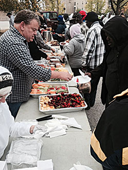 Members of the volunteer group Beggars for the Poor serve a gourmet meal to the homeless in downtown Indianapolis on Oct. 17. The &lsquo;banquet level&rsquo; menu became available through the generosity of Bishop Chatard High School in Indianapolis. (Submitted photo)
