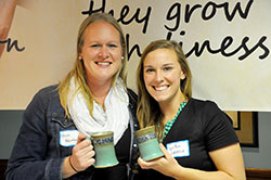 Erica Heinekamp, left, and LeeAnn Zatkulak pose with the handmade mugs they received as the first winners of the Mary and Martha Awards from the Sisters of St. Benedict at Our Lady of Grace Monastery in Beech Grove. Heienkamp, recipient of the Mary &ldquo;Heart of Prayer&rdquo; Award, and Zatkulak, recipient of the Martha &ldquo;Heart of Service&rdquo; Award, were honored at a reception at the monastery on Oct. 25. (Photo by Natalie Hoefer)