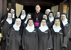 Members of the Discalced Carmelite Monastery of St. Joseph in Terre Haute pose on Oct. 10 with Archbishop Joseph W. Tobin on the monastery&rsquo;s grounds. Earlier that day, Archbishop Tobin was the principal celebrant of a Mass at the monastery that marked the 500th anniversary of the birth of St. Teresa of Avila, who founded the women&rsquo;s branch of the Discalced Carmelites. (Photo by Sean Gallagher)