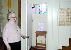 Carolyn Fenton stands outside a confessional at St. Joseph Church in Shelbyville. The sacrament of reconciliation has long had a special place in her life after a priest&rsquo;s advice led her to the husband of her dreams, and to the realization that Jesus is present in the sacrament. (Photo by John Shaughnessy)