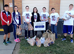 Members of the youth group at St. Anthony of Padua Parish in Clarksville pose by the cans they collected by going door to door in a neighborhood&mdash;one of many service projects during Food Fast, their annual 24-hour fasting and service event, on Feb. 20. (Submitted photo by Stacy Gillenwater)