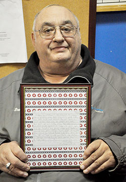 In this April 4 photo at Terre Haute Catholic Charities Foodbank, employee Dan Snider holds the letter that Anthony LePorte wrote to him at the age of 14, stating that Snider was &ldquo;the father I always wanted.&rdquo; (Photo by Natalie Hoefer)
