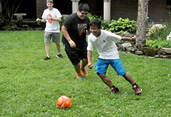 Thomas Thang, right, and Josiah Guerra-Cristobal, play with a soccer ball on June 17, 2015, at Bishop Simon Brut&eacute; College Seminary in Indianapolis during its annual Bishop Brut&eacute; Days, a vocations retreat and camping experience for teenage boys. Looking on is Nathan Herr, left. (File photo by Sean Gallagher)