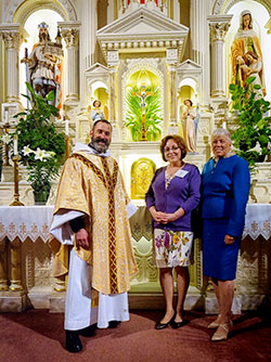 Father Aaron Pfaff, pastor of St. Joseph Parish in Shelbyville, poses with newly confirmed Catholic Edy Ballard and her sponsor, Carol McElroy, in St. Joseph Church after the parish&rsquo;s Easter Vigil Mass on March 26. (Submitted photo)