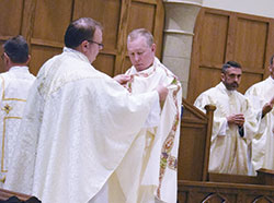 Father C. Ryan McCarthy, left, places a deacon&rsquo;s dalmatic on transitional Deacon Luke Reese during a May 31 ordination Mass at the Cathedral of Our Lady of Walsingham in Houston in which Deacon Reese and two other men were ordained for the Personal Ordinariate of the Chair of St. Peter. Father McCarthy is pastor of Our Lady of the Most Holy Rosary Parish in Indianapolis, where members of the ordinariate in central and southern Indiana worship. (Submitted photo)