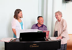 Franciscan Sister Christine Ernstes, right, shares a smile with Anna Johannigman and Anna&rsquo;s father, Joe Johannigman, before Mass on June 12 at Immaculate Conception Church in Millhousen in the Batesville Deanery. Anna sings during Mass while Joe plays the piano. (Submitted photo by Amy Hermesch)