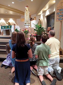 The Reynolds family, who are members of St. John Paul II Parish in Clark County, pray the rosary before the traveling pilgrimage statue of Our Lady of Fatima in the parish&rsquo;s St. Paul Church in Sellersburg on Aug. 21. They are Elizabeth, left, Barbara, Rebecca, Anna Kate, William and Joseph. (Photo by Natalie Hoefer)