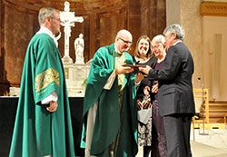 Deacon Michael Braun, left, and archdiocesan Office of Pro-Life and Family Life director Rebecca Niemerg, center, look on as Msgr. William F. Stumpf, vicar general, presents Ann and Jim Recasner with the 2016 Archbishop O&rsquo;Meara Respect Life Award during the Respect Life Sunday Mass at SS. Peter and Paul Cathedral in Indianapolis on Oct. 2. (Photo by Natalie Hoefer)