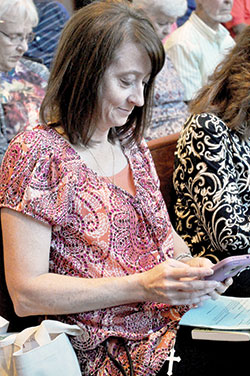 Agenia Hurrle, a member of St. Barnabas Parish in Indianapolis, uses a smart phone to share a &ldquo;mercy pledge&rdquo; on Oct. 8 during the Marian Jubilee at St. Bartholomew Church in Columbus. (Photo by Sean Gallagher)