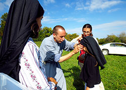 Franciscan of the Immaculate Brother Gabriel Cortes adjusts the veil of Marianne Cloutier, who is playing the part of Jacinta Marto, one of three shepherd children Our Lady of Fatima appeared to in Fatima, Portugal, in 1917. Watching from the left is Maria Siefker, who plays L&uacute;cia dos Santos, and Marianne&rsquo;s older sister, Maude Cloutier. (Photo by Katie Breidenbach)