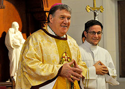 Cardinal-designate Joseph W. Tobin laughs while making closing remarks during a Nov. 9 Mass at Bishop Simon Brut&eacute; College Seminary in Indianapolis. Assisting at the Mass as an altar server is Eric Gehlhausen, right, a seminarian of the Diocese of Evansville, who is a junior at Bishop Brut&eacute;. (Photo by Sean Gallagher)