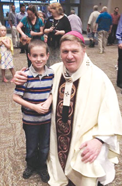 Archbishop Joseph W. Tobin poses on Aug. 13 with Ryan Rutherford after the dedication Mass of the new church of St. Mary Parish in Greensburg. Ryan is a third-grade student at the parish&rsquo;s school, and recently offered advice to now-Cardinal Tobin as he prepares to leave the Hoosier state to lead the Archdiocese of Newark, N.J. (Submitted photo) 