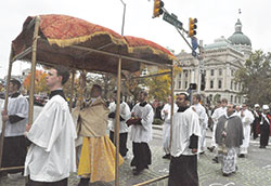 Father Rick Nagel, pastor of St. John the Evangelist Parish in Indianapolis, holds a monstrance while leading a eucharistic procession on Nov. 19 past the Indiana Statehouse during the 10th annual Indiana Catholic Men&rsquo;s Conference. (Photo by Sean Gallagher) 