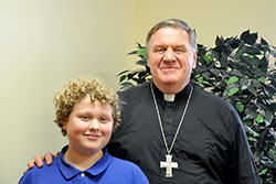 Cardinal Joseph W. Tobin poses with Miles Barth, a seventh-grade student at St. Thomas Aquinas School in Indianapolis, after the young reporter conducted an interview with the cardinal at the Archbishop Edward T. O&rsquo;Meara Catholic Center in Indianapolis for the school&rsquo;s newspaper on Dec. 1. (Photo by Natalie Hoefer) 