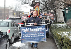 Ken Ogorek, archdiocesan director of catechesis, leads a precession along North Meridian Street in Indianapolis on Jan. 22, 2016, during last year&rsquo;s solemn prayerful remembrance of the Supreme Court&rsquo;s Roe v. Wade decision that legalized abortion. This year&rsquo;s Mass and procession will take place on Jan. 23. (Criterion file photo by Natalie Hoefer) 