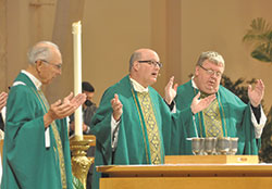Msgr. William F. Stumpf, center, prays the eucharistic prayer during the Oct. 4, 2015, archdiocesan Respect&nbsp;Life Mass at SS. Peter and Paul Cathedral in Indianapolis. On Jan. 9, he was elected archdiocesan administrator by the priests who make up the archdiocesan college of consultors, and will lead the Church in central and southern Indiana until a new archbishop is appointed. Joining Msgr. Stumpf at the altar are Father Paul Landwerlen, left, and Father Robert Robeson. (File photo by Natalie Hoefer) 