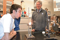 Bishop Chatard High School chemistry teacher Dan McNally smiles at Daniel Burger&rsquo;s reaction to an experiment. (Submitted photo)