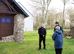 Father Anthony Hollowell, left, and Father Kyle Rodden of the Archdiocese of Indianapolis listen as a member of the Sisters of Providence shares details about the birthplace of St. Theodora Gu&eacute;rin&mdash;Indiana&rsquo;s only saint&mdash;in Etables-sur-Mer, France. (Photo by Father Eric Augenstein)
