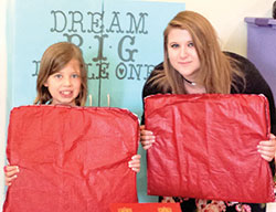 Cassandra Poynter, 17, right, and Children&rsquo;s Liturgy of the Word participant Hannah Seitz, both of Nativity of Our Lord Jesus Christ Parish in Indianapolis, pose with mats and the cabinet Cassandra made to improve the children&rsquo;s ministry in her parish. Cassandra&rsquo;s efforts helped her to earn her the Girl Scout Gold Award. (Submitted photo)
