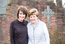 Sisters Jeanne Schmidt, left, and Kathy Kruer smile in a grotto on the grounds of St. Elizabeth Catholic Charities in New Albany. The women will receive the Spirit of Hope Award at the organization&rsquo;s annual fundraiser gala on April 27. (Submitted photo)