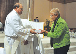 Linda Smith, a member of St. Michael Parish in Bradford, receives holy oils for her New Albany Deanery faith community from Deacon Jeffrey Powell during the archdiocesan chrism Mass on April 11 at SS.&nbsp;Peter and Paul Cathedral in Indianapolis. Deacon Powell ministers at Our Lady of Perpetual Help Parish in New Albany. (Photo by Sean Gallagher)	