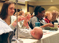 Ruby Dlugosz of St. Michael the Archangel Parish in Indianapolis holds a rosary over her 4-month old son, Daniel, during the Indiana Catholic Women&rsquo;s Conference in Indianapolis on March 25. (Photo by Victoria Arthur)