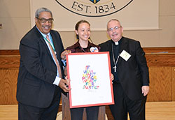 Providence Sister Tracey Horan receives the Catholic Campaign for Human Development&rsquo;s (CCHD) 2017&nbsp;Cardinal Bernardin New Leadership Award from CCHD director Ralph McCloud, left, and Bishop David P. Talley of Alexandria, La., at the Archbishop Edward T. O&rsquo;Meara Catholic Center in Indianapolis on&nbsp;June 14. (Photo by Natalie Hoefer)
