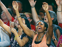 Young people lift their arms in prayer as Catholic musician Matt Maher performs on July 3 during the &ldquo;Convocation of Catholic Leaders: The Joy of the Gospel in America&rdquo; in Orlando, Fla. Leaders from dioceses and various Catholic organizations gathered for the July 1-4 convocation. (CNS photo/Bob Roller)
