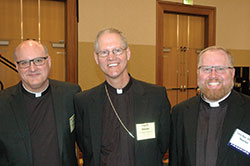 Msgr. William F. Stumpf, archdiocesan administrator, left, Archbishop Paul D. Etienne of Anchorage, Alaska, and Father Joseph Newton, left, archdiocesan vicar judicial, pose for a photo before the start of the spring meeting of the U.S.&nbsp;Conference of Catholic Bishops in Indianapolis on June&nbsp;14. (Photo by John Shaughnessy)