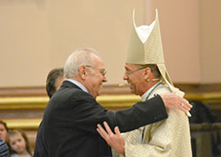 Archbishop Charles C. Thompson shares a smile and a hug with his father Coleman Thompson as family members presented the offertory gifts to the archbishop during his installation Mass at SS.&nbsp;Peter and Paul Cathedral in Indianapolis on July 28. (Photo by Natalie Hoefer)