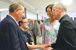 Archbishop Charles C. Thompson shakes hands with Tommy Steiner while the youth&rsquo;s parents, Bob and Ann, look on. The Steiners, members of Our&nbsp;Lady of Perpetual Help Parish in New Albany, greeted the archbishop at a reception after he celebrated Mass at their parish on July 30. (Photo by Natalie Hoefer)