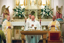 Father Wilfred &ldquo;Sonny&rdquo; Day celebrates Mass on May 5 at St. John the Baptist Church in Starlight to mark the 50th anniversary of his ordination to the priesthood. Concelebrating the Mass are retired Msgr. Paul Richart, left, Father Eric Johnson and Father Thomas Clegg. Father Day is pastor of St. John the Baptist Parish in Starlight and dean of the New Albany Deanery. (Submitted photo by Paul Bierman)