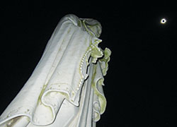 With nightlike darkness all around, a statue of Mary on the grounds of the Auburn, Ky., headquarters of the Fathers of Mercy religious order, stands on Aug. 21 beneath a total solar eclipse with the sun&rsquo;s corona shining around the edge of the moon that passed on the afternoon of that day between the sun and the Earth. Students from Lumen Christi Catholic High School in Indianapolis traveled to Auburn to view the eclipse. (Submitted photo)