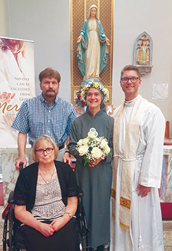 Sister Solanus Casey Danda, center, poses on July 11 in St. Theresa Church in Corpus Christi, Texas, with her parents, Richard and Katherine Danda, and her brother, Father Sean Danda, after professing perpetual vows as a member of the Society of Our Lady of the Trinity. (Submitted photo)